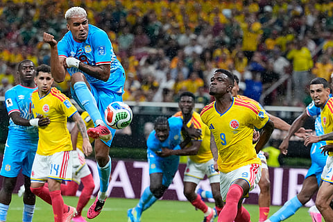 Congo's Charles Pickel (18) takes a shot at goal as Colombia's Jhon Cordoba (9) reacts during the World Cup Group K soccer match between Colombia and Congo in Zapopan, near Guadalajara, Mexico.