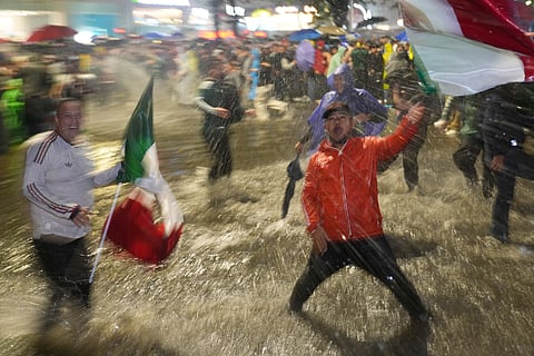 Fans celebrate under the rain after Mexico defeated Czechia in a World Cup Group A soccer match in Mexico City, Wednesday, June 24, 2026.