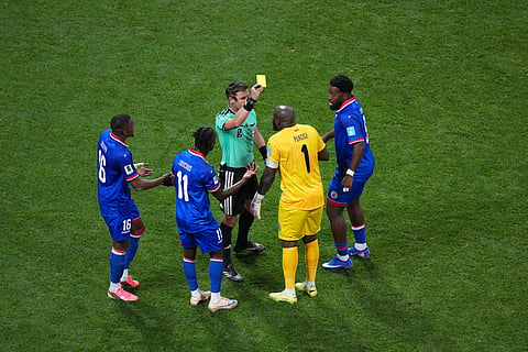 Referee Danny Makkelie, of The Netherlands, gives Haiti goalkeeper Johny Placide (1) a yellow card during the World Cup Group C soccer match between Morocco and Haiti in Atlanta, Wednesday, June 24, 2026.