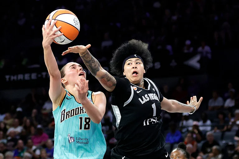 New York Liberty guard Pauline Astier (18) shoots against Las Vegas Aces forward Kierstan Bell (1) during the first half of an WNBA basketball game in Las Vegas. - | Photo: Steve Marcus/Las Vegas Sun via AP