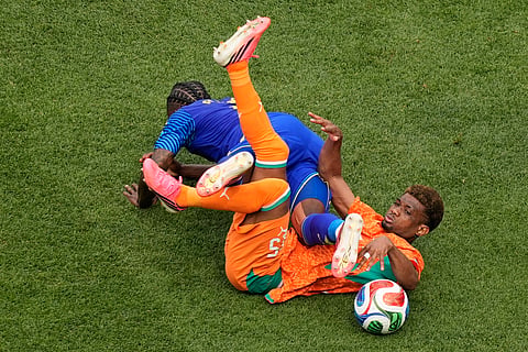 Curaçao's Sherel Floranus (5) tackles Ivory Coast's Amad Diallo (15) during the World Cup Group E soccer match between Curacao and Ivory Coast in Philadelphia, Thursday, June 25, 2026.