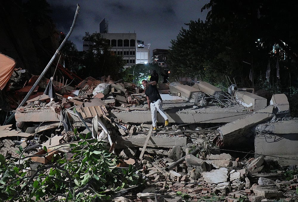 A man jumps on a collapsed building after an earthquake in Caracas, Venezuela. - | Photo: AP/Adrian Naranjo