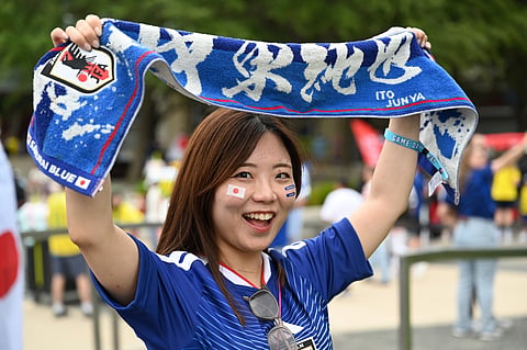 A fan cheers outside the stadium before the World Cup Group F soccer match between Japan and Sweden in Arlington