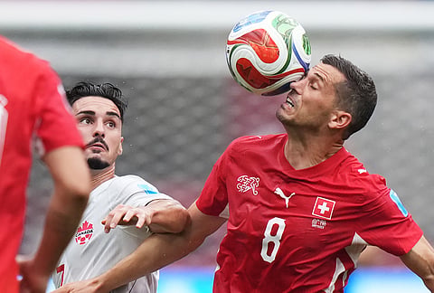 Switzerland's Remo Freuler (8) plays the ball in front of Canada's Stephen Eustaquio (7) during the World Cup Group B soccer match between Switzerland and Canada in Vancouver, British Columbia.