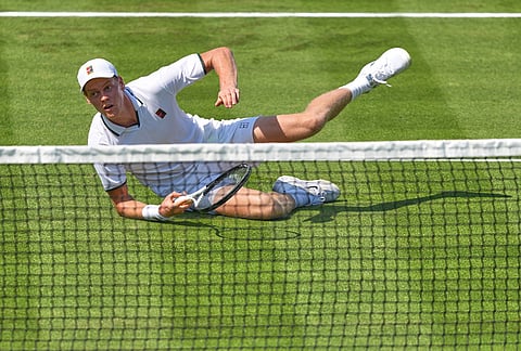 Jannik Sinner of Italy falls on the court during a tennis exhibition match against Cameron Norrie of Great Britain at the Hurlingham Tennis Club in London.