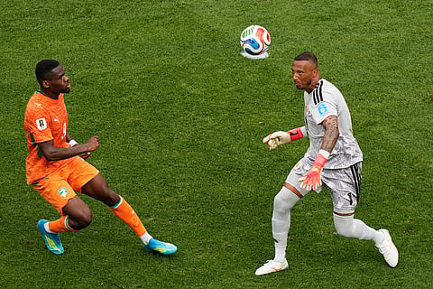 Curaçao goalkeeper Eloy Room (1) eyes the ball in front of Ivory Coast's Ange-Yoan Bonny (9) during the World Cup Group E soccer match between Curacao and Ivory Coast in Philadelphia, Thursday, June 25, 2026.
