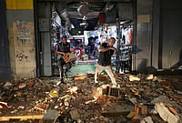 | Photo: AP/Pedro Mattey : Men walk among rubble after an earthquake in Caracas, Venezuela.
