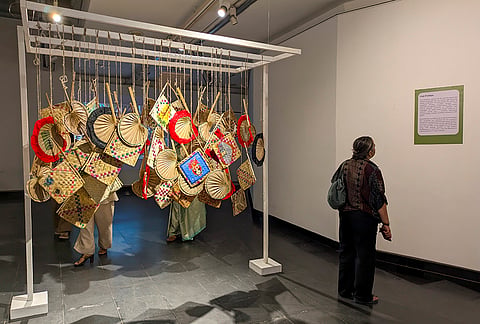 A visitor looks at an installation of 'hat pakhas', hand woven fans, at a week-long exhibition, De la Terre a l'Ame (From the Soil to the Soul), at Alliance Francaise de Delhi, in New Delhi.