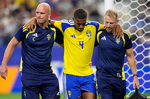 Sweden's Isak Hien, center, leaves the field injured during the World Cup Group F soccer match against Japan in Arlington.
