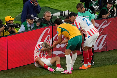 Paraguay's Julio Enciso (19) is helped up by Australia's Alessandro Circati (3) after crashing into the boards during the World Cup Group D soccer match between Paraguay and Australia in Santa Clara, Calif., near San Francisco, Thursday, June 25, 2026.