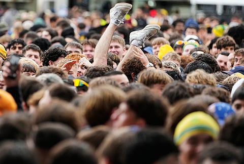 A man's legs pop up after he is dumped while crowd surfing as fans watch large screens in a park in Sydney, as Australia and Paraguay play in their World Cup Group D soccer match.