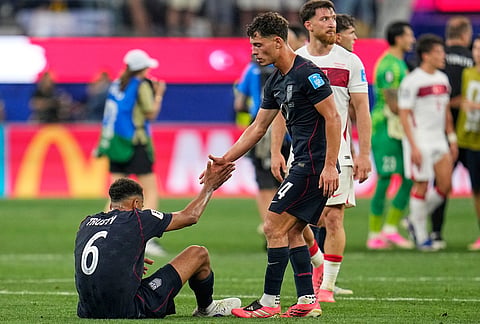 United States' Sebastian Berhalter (14) assists teammate Auston Trusty (6) to his feet following the World Cup Group D soccer match between Turkey and the United States in Inglewood, Calif., near Los Angeles.