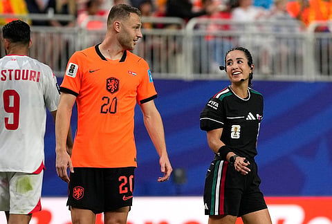 Referee Katia Itzel Garcia of Mexico talks with Netherlands' Teun Koopmeiners (20) during the World Cup Group F soccer match between Tunisia and the Netherlands in Kansas City, Missouri.