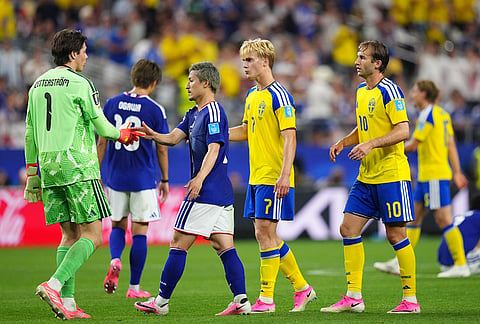 Japan's Daizen Maeda, center, greets to Sweden goalkeeper Jacob Widell Zetterstrom after the World Cup Group F soccer match in Arlington, Texas, near Dallas.