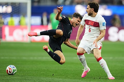 United States' Giovanni Reyna falls as Turkey's Orkun Kokcu looks on during the World Cup Group D soccer match in Inglewood, Calif., near Los Angeles, Thursday, June 25, 2026.