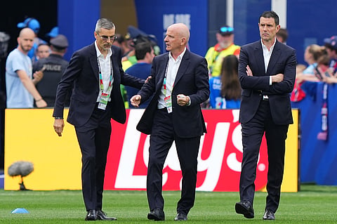 France assistant coach Guy Stephan, center, takes a walk on the pitch ahead of the match.