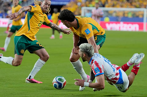 Paraguay's Julio Enciso, right, reacts after being tackled by Australia's Alessandro Circati, center, during the World Cup Group D soccer match between Paraguay and Australia in Santa Clara, Calif., near San Francisco, Thursday, June 25, 2026.