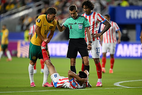Paraguay's Diego Gomez (8) on the ground, is helped by Australia's Ajdin Hrustic (10) during the World Cup Group D soccer match between Paraguay and Australia in Santa Clara, Calif., near San Francisco, Thursday, June 25, 2026.