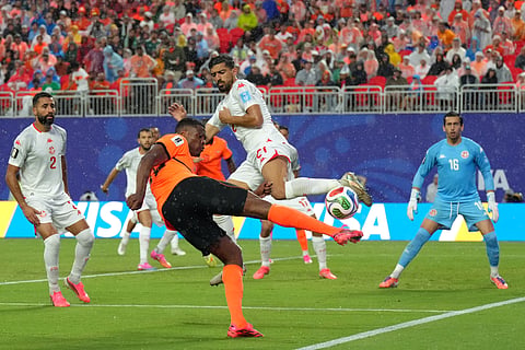 A Tunisian player tries to block a shot from Netherlands' Denzel Dumfries during the World Cup Group F soccer match between Tunisia and the Netherlands in Kansas City, Mo., Thursday, June 25, 2026.