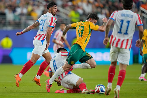 Australia's Aiden O'Neill (13) battles for the ball with Paraguay's Diego Gomez (8) during the World Cup Group D soccer match between Paraguay and Australia in Santa Clara, Calif., near San Francisco, Thursday, June 25, 2026.