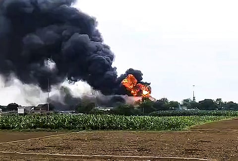 Flames and dark smoke billow after a fire broke out as a LPG tanker collides with a toll plaza, in Kaushambi, Uttar Pradesh. 