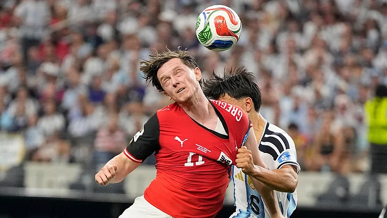 Austria's Michael Gregoritsch (11) and Argentina's Lisandro Martinez (6) jump for the ball - AP