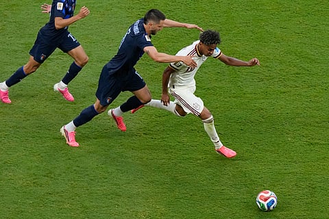 Spain's Lamine Yamal (19) battles for the ball with Uruguay's Rodrigo Bentancur (6) during the World Cup Group H soccer match