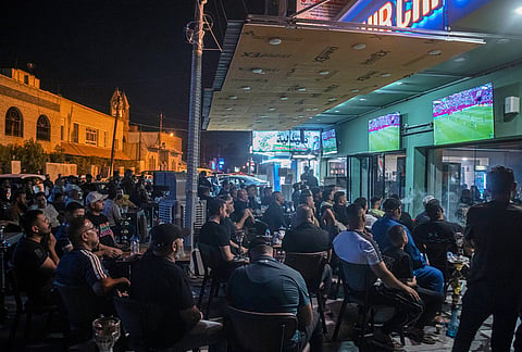 Soccer fans watch the World Cup Group I match between Senegal and Iraq at an outdoor cafe in downtown Baghdad, Iraq.
