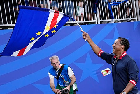 Cape Verde head coach Bubista waves the flag as he celebrates with fand after the World Cup Group H soccer match between Cape Verde and Saudi Arabia in Houston.