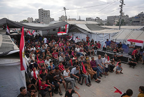 Palestinians watch a live broadcast of the World Cup soccer match between Egypt and Iran on a screen in Nuseirat, central Gaza Strip.