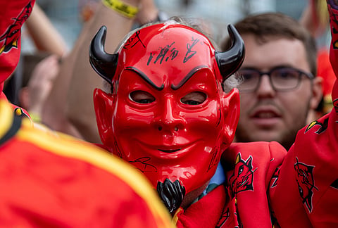 A Belgium fan wearing a red devil mask marches toward B.C. Place prior to a World Cup Group G soccer match against New Zealand, in Vancouver.