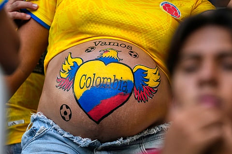 A supporter has her stomach painted in Colombia colours before the World Cup Group K soccer match between Colombia and Portugal in Miami Gardens