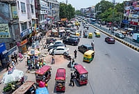 | Photo: PTI/Arun Sharma : Vehicles, roadside vendors and commercial encroachments occupy a footpath, forcing pedestrians to use the carriageway, at Laxmi Nagar, in New Delhi. The Supreme Court has held that the right to walk on a demarcated footpath is a fundamental right. 