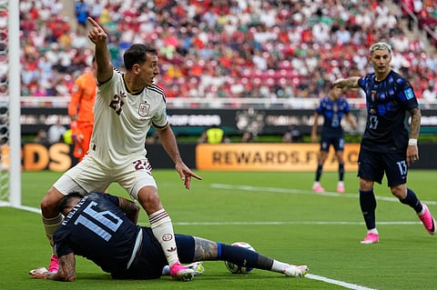 Spain's Mikel Oyarzabal, top, gestures after competing for the ball against Uruguay's Mathias Olivera