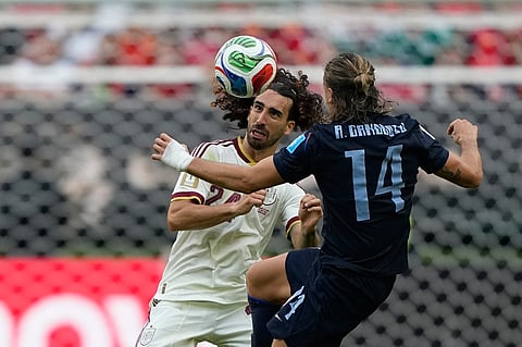 Spain's Marc Cucurella, left, and Uruguay's Agustin Canobbio compete for the ball during the World Cup Group H soccer match
