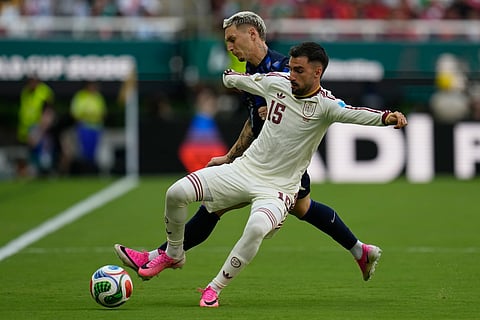 Uruguay's Guillermo Varela (13) challenges for the ball with Spain's Alex Baena (15) during the World Cup Group H soccer match