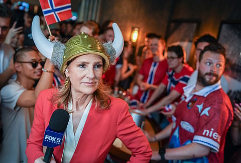 A news anchor wearing a viking hat covers a World Cup soccer watch party for Norway and France, in New York.