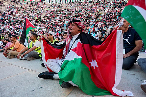 A Jordanian soccer fan wearing a traditional keffiyeh and draped in national flags watches the FIFA World Cup Group J match between Jordan and Argentina on a large screen at the Roman Amphitheater in downtown Amman, Jordan, early Sunday, June 28, 2026.
