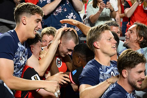 Austria's Sasa Kalajdzic (14), center left, is mobbed by teammates after scoring their third goal during the World Cup Group J soccer match between Algeria and Austria in Kansas City, Mo., Saturday, June 27, 2026.