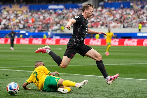 Canada's Alistair Johnston jumps over South Africa's Oswin Appollis during the World Cup round of 32 soccer match in Inglewood,