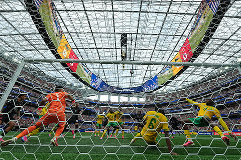 South Africa players battle to clear the ball during the World Cup round of 32 soccer match between South Africa and Canada 