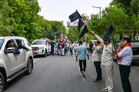 Workers of the Anjaan Aadmi Party show black flags to the convoy of Samajwadi Party president Akhilesh Yadav ahead of the launch of the party's 'Vision India' anti-paper leak campaign, in Prayagraj, Uttar Pradesh.