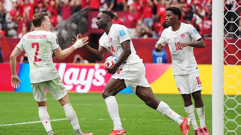 Canada's Promise David (24) retrieves the ball and celebrates his goal with Alistair Johnston (2) and Jonathan David (10) during the World Cup Group B soccer match between Switzerland and Canada in Vancouver, British Columbia. - (Darryl Dyck/The Canadian Press via AP)