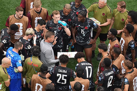 Canada head coach Jesse Marsch, center, instructs his players during a hydration break of the World Cup round of 32 soccer match