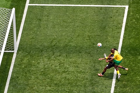 South Africa's Mbekezeli Mbokazi (14) clears the ball during the World Cup round of 32 soccer match 