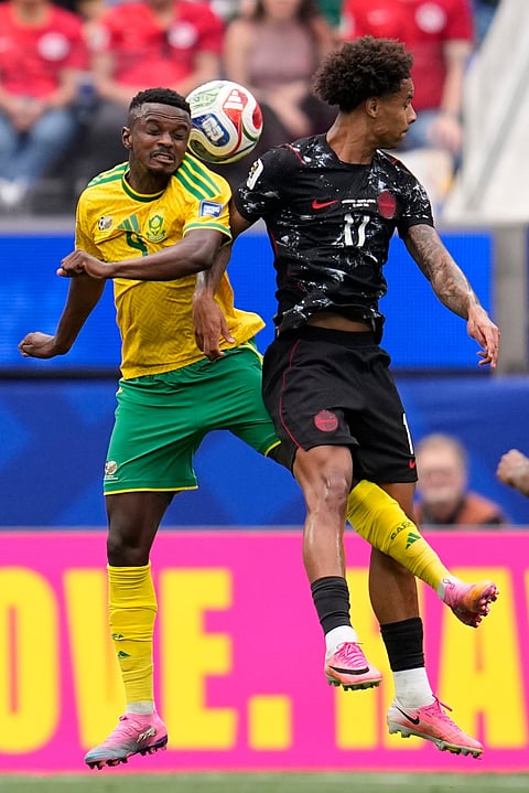 South Africa's Teboho Mokoena, left, heads a ball next to Canada's Tajon Buchanan during the World Cup round of 32 soccer match