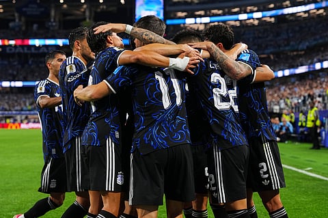 Argentina players embrace Lautaro Martinez, center, to celebrate after he scored his side's second goal on a penalty kick during the World Cup Group J soccer match against Jordan in Arlington, Texas, near Dallas, Saturday, June 27, 2026