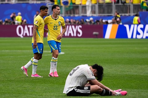 Brazil's Douglas Santos (16) and Brazil's Gabriel Martinelli (22) celebrate at the end of the World Cup round of 32 soccer match between Brazil and Japan in Houston