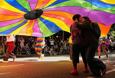 Nadja Thompson, left, kisses Olivia Cortez, right, under a rainbow parachute during the Seattle Pride Parade Sunday, June 28, 2026, in Seattle. 