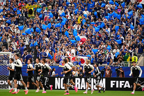 Japan fans cheer for their national team before the World Cup round of 32 soccer match between Brazil and Japan in Houston